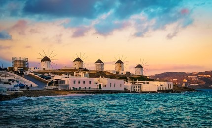 sunset view of mykonos seafront with windmills