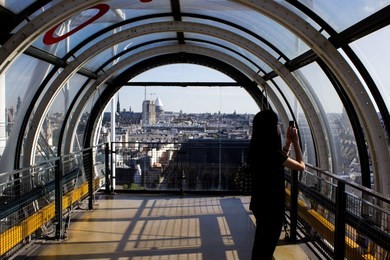girl photographing parisian skyline on rooftop of centre pompidou, paris