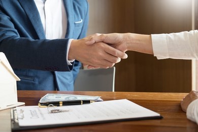 house developers agent or financial advisor and customers shaking hands after signing document making deal as successful agreement, contract with a firm