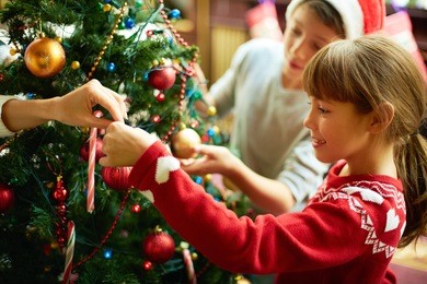 portrait of happy girl decorating christmas tree