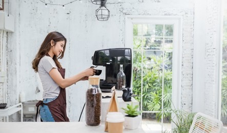 startup successful small business owner beauty girl using coffee machine in coffee shop restaurant. portrait of young asian tan woman barista cafe owner. sme entrepreneur business concept
