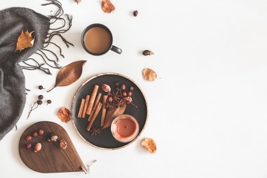 autumn cozy composition. cup of coffee, plaid, candle, dried leaves on white background. autumn, fall concept. flat lay, top view, copy space
