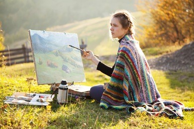 young artist painting an autumn landscape