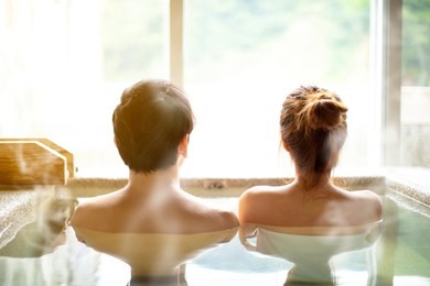 rear view young couple relaxing in hot springs 