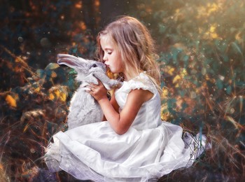 children in beautiful white dress play with rabbit. little girl holding in hands little rabbit.