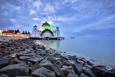 malacca straits mosque ( masjid selat melaka) with beautiful blue hour sunset background. it is a mosque located on the man-made malacca island near malacca town, malaysia

