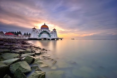 majestic view of malacca straits mosque ( masjid selat melaka) with beautiful sunset background. it is a mosque located on the man-made malacca island near malacca town, malaysia  