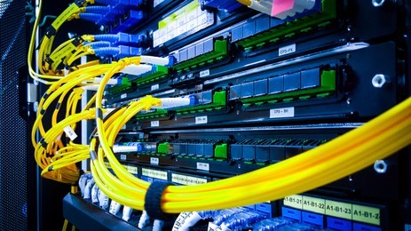close up fiber optic in server room , network cables installed in the rack. yellow and blue 