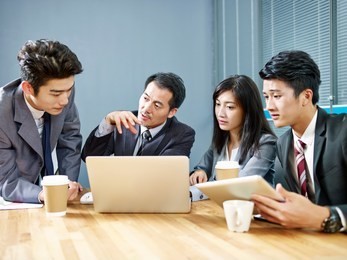 asian corporate people meeting in office discussing business using laptop computer.