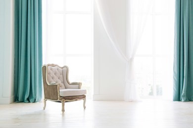 vintage armchair against white wall and big window with curtain. space for your copy