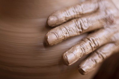  hands of potter do a clay pot
