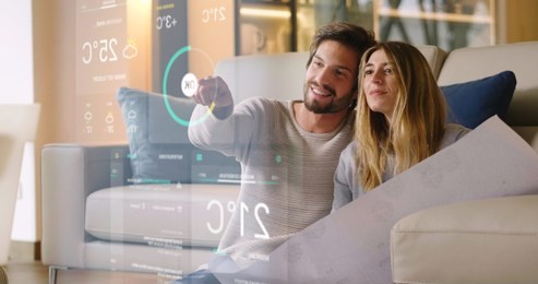 a couple sitting on the sofa controls all the functions of the house such as wi-fi, heating, lighting, television through holography. concept of, home automation, automations, future, technology.