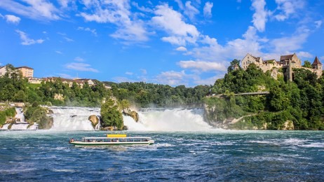 tourist boat with people floating to the waterfall the rhine falls. it is one of the main tourist attractions, schaffhausen, switzerland.