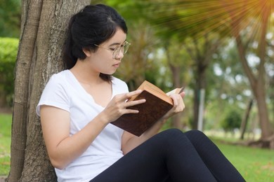 young student girl reading a book in the school park - thailand people