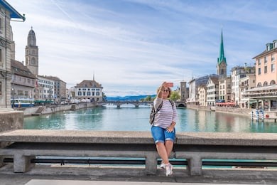 woman taking picture of zurich and limmat river, switzerland