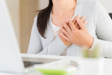 closeup business woman having heart attack. woman touching breast and having chest pain after long hours work on computer. office syndrome, healthcare and medical concept.