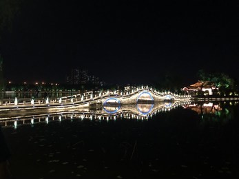 lighted bridge with reflection in daming lake in jinan, china