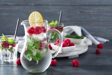 glass jug of fresh raspberry mojito on wooden table