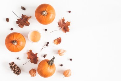 autumn composition. pumpkins, candles, dried leaves on white background. autumn, fall, halloween concept. flat lay, top view, copy space