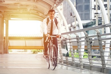 hispanic businessman riding a bicycle to work.