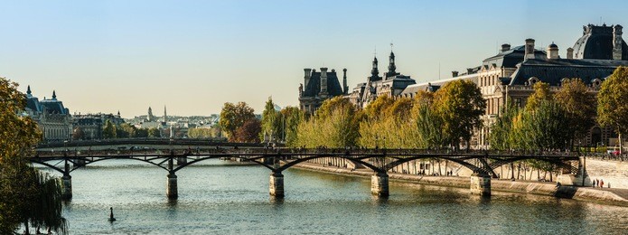 panorama of the louvre museum and the bridge of arts in autumn
