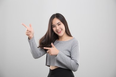 smiling woman pointing finger side. isolated portrait on white.