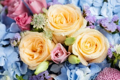 close up of beautiful soft colour flower bouquet with blue hydrangea, peach roses, pink lisianthus, ping pong mums and astrantia.
