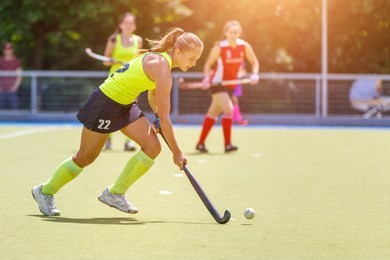 young hockey player woman with ball in attack playing field hockey game