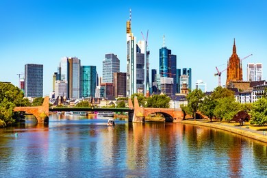 scenic summer view of the business corporate downtown bank district with high tall skyscraper buildings and bridge over the main river in frankfurt am main, germany