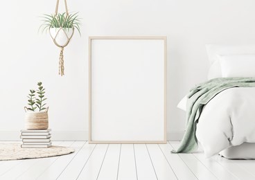 poster mockup with wooden vertical frame standing on floor in bedroom interior with bed, green plaid and plants on white wall. 3d rendering.