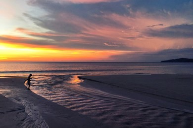 panoramic view of sunset kid playing on the beach at karon beach in phuket, thailand