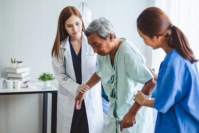 asian doctor woman and nurse encourage disabled old man patient sitting on bed at hospital, asian medical concept
