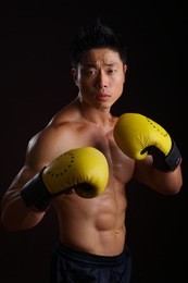 asian boxer in his attacking stance with yellow gloves