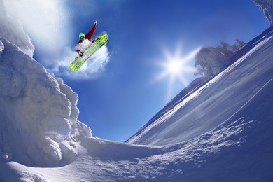 snowboarder jumping against blue sky
