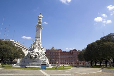 the statue of christopher columbus with a blue sky background. the monument is located in the plaza de mayo (may square), in front of the casa rosada (pink house) in buenos aires, argentina