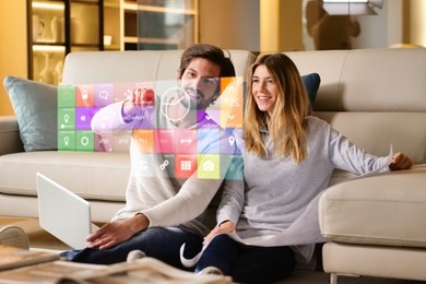 a couple sitting on the sofa controls all the functions of the house such as wi-fi, heating, lighting, television through holography. concept of, home automation, automations, future, technology.