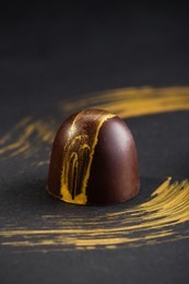 luxury bonbons painted with gold on black background. exclusive handmade chocolate candy. product concept for chocolatier