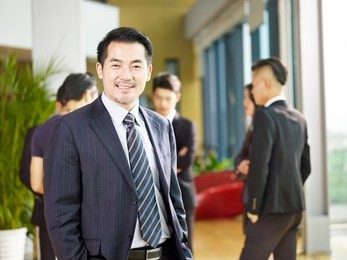portrait of a senior business manager arms crossed looking at camera with a big smile.