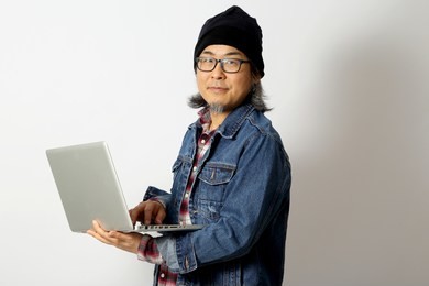 the asian man with denim shirt and beanie standing on the white background.