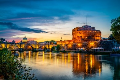 saint angelo castle and old bridge with st peter's basilica in the background near  tiber river 