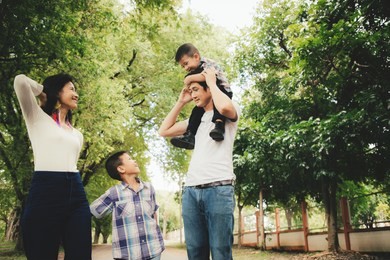 happy asian family enjoying family time together in the park. family concept