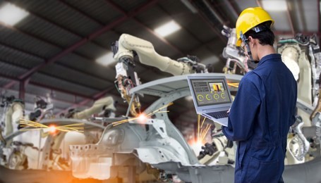 industry 4.0 robot concept .engineers use laptop computers for machine maintenance, automation tools, robot arm at the factory.