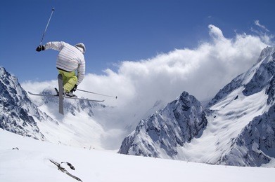 freestyle ski jumper with crossed skis in high mountains