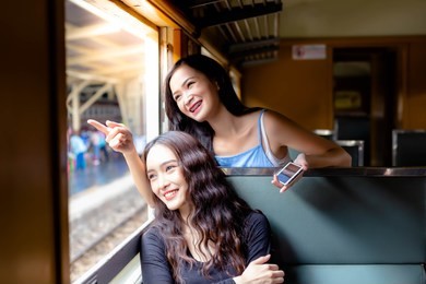 beautiful tourist women or traveler women are best friend. they’re traveling to tourism location by using retro train. lovely women get enjoying life and feel happiness together with face