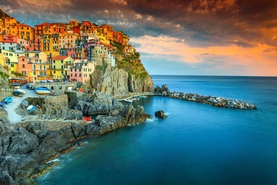 amazing colorful mediterranean sunset, fantastic panorama of manarola touristic village in cinque terre national park, liguria, italy, europe