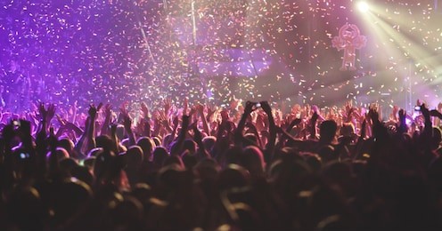 a crowded concert hall with scene stage lights, rock show performance, with people silhouette
