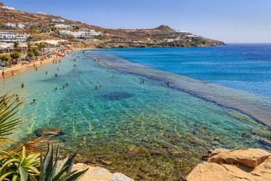 paradise beach ,kalamopodi, of mykonos, greece. sunny with blue sky and crystal clear water. paradise is definitely the most famous  beach of mykonos: thin sand and emerald green water.