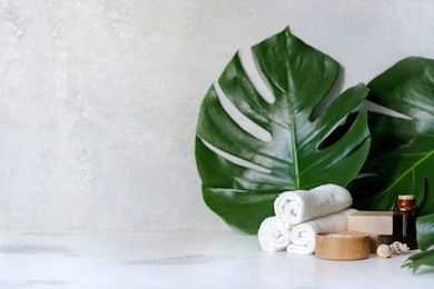 spa and massage treatments on white, marble background monstera leaves. flat lay. top view