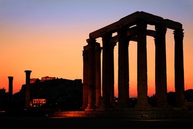 athens, greece. the temple of olympian zeus (considered one of the biggest of the ancient world) after sunset, with acropolis in the background.