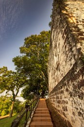 staircases from a famosa to st paul church ,  ancient ruin of st. paul church in melaka city, malaysia, against a blue cloudy sky exterior view of st. paul's church in malacca,